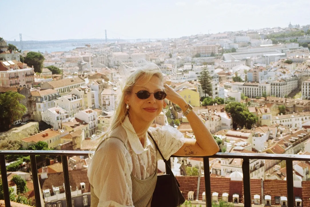 Ana in sunglasses at a viewpoint over Lisbon's rooftops